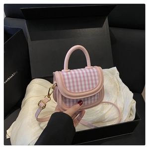 Detail der rosa karierten Mädchenhandtasche mit Perle, Schleife und Ledergriff in Box