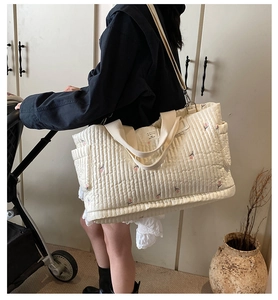 Gesteppte beige Wickeltasche mit rosa Blumenstickerei und verstellbarem Schultergurt