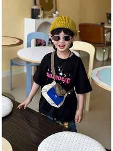 Street style kids outfit with black t-shirt, yellow beanie and contrast shoulder bag