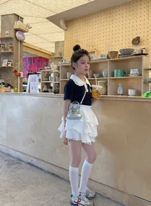 Gros plan d'un mini sac à paillettes argentées avec polo noir et jupe en dentelle