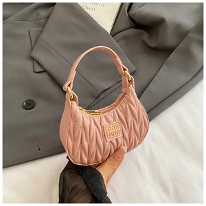 Detail of pink matelassé mini handbag featuring pleated texture and gold metal zipper