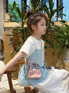 Gros plan d'une fille portant un mini sac coquillage à paillettes roses avec bandoulière