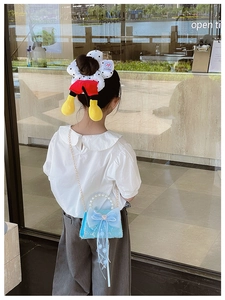 Détail du sac fille en dentelle bleue avec anse perle et accessoire cheveux Mickey