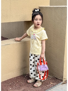Detail of girls summer outfit featuring yellow ice cream tee and purple contrast handbag