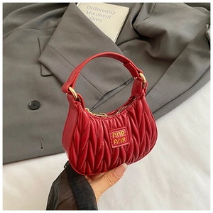 Detailed close-up of red mini matelasse bag with pleated texture and golden hardware