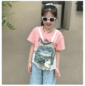 Close-up of kids mini ocean-themed backpack with glowing moon charm and coral print