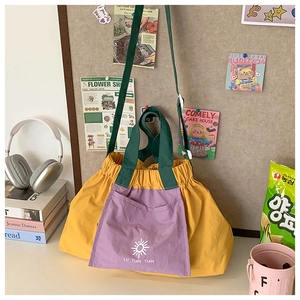 Detail of vibrant color-block canvas tote bag with drawstring and sun logo branding