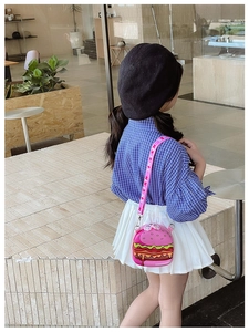 Pink hamburger shaped kids crossbody bag shown on child model in outdoor setting