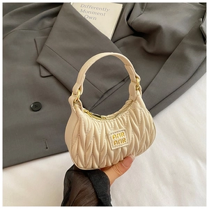 Detail of a beige pleated mini handbag for girls with golden metallic hardware