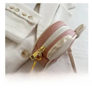 Close-up of the smooth zipper and lychee pattern leather on a pink mini bag