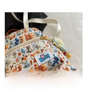 Close-up of children's mini backpack with forest animal prints and woven brand label