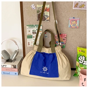 Detail of canvas tote bag with contrast pocket and sun logo on a stylized desk