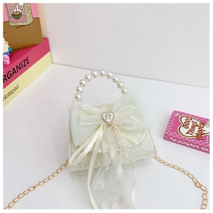 Détail de sequins avec nœud en tulle et poignée en perles sur sac pour filles