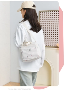 Détail du sac cabas matelassé blanc avec broderie florale rose et bandoulière