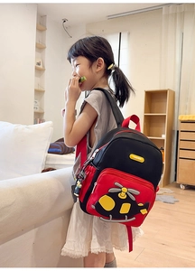 Close-up of cute cartoon helicopter pattern on red and black kids backpack for school