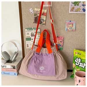 Detail of color-block kid bag with orange straps, purple pocket and drawstring top