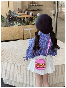 Close-up of pink hamburger-shaped silicone shoulder bag for kids on a model