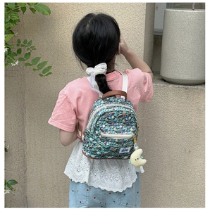 Detail of teal sea-themed mini backpack with shell patterns and moon plush charm