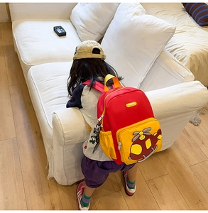 Detail of red and yellow kids backpack with 3D helicopter motif and side mesh pocket