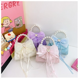 Détail de sacs à main en dentelle pailletée pour enfants avec perles et grands nœuds
