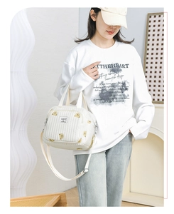 Détail du sac cabas matelassé blanc avec motif ours, doubles poignées et bandoulière réglable