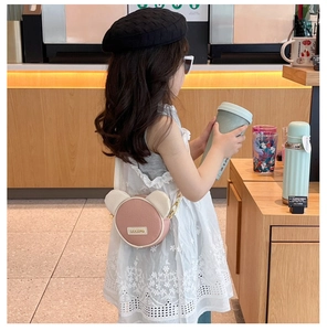 Detailed view of kids' pink cartoon bear crossbody bag with plush ears on a cute strap