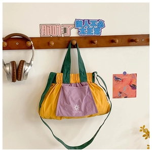 Detailed view of kids crossbody bag featuring yellow body with purple front pocket detail