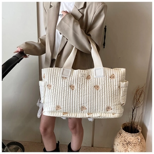 Detail der gesteppten Wickeltasche mit Bärenbestickung und praktischer Seitentasche