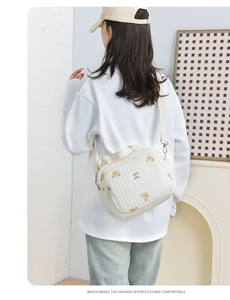 Vue arrière d'un mannequin portant un sac matelassé beige aux motifs d'oursons