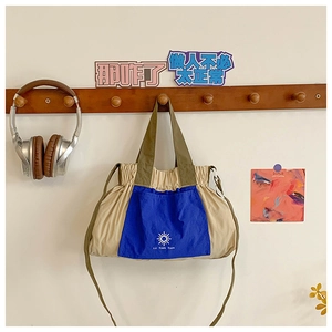Close-up of color-block kids tote bag with drawstring details and woven logo patch