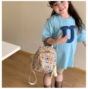 Close-up of children's backpack featuring orange fox prints and dual zipper pockets