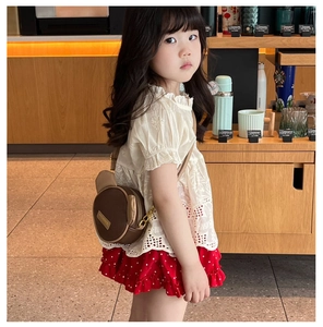 Detail of cute bear-shaped brown leather crossbody bag worn by a girl in style