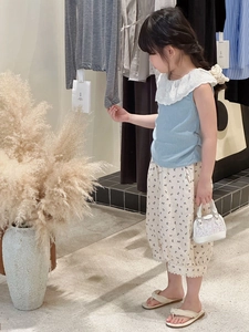 Détail de l'ensemble d'été pour bébé fille : haut bleu à col dentelle et pantalon à fleurs