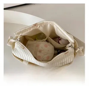 Detail view of large quilted diaper bag interior with organized compartments for baby gear