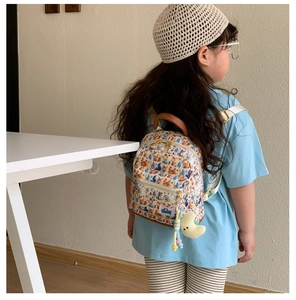 Toddler backpack with fox forest pattern shown on a young girl in a cozy outdoor setting