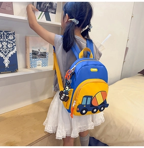 Detail view of cartoon truck backpack with teddy bear charm on child model side profile