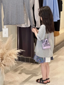 Détail d'une tenue fille avec t-shirt gris et jupe patchwork colorée en coton
