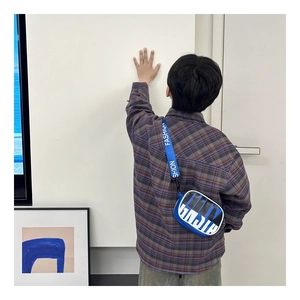 Close-up of a blue and white crossbody bag featuring a fashion-printed fabric strap for kids