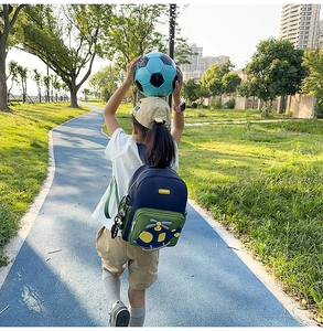 Outdoor view of a navy and green kids backpack with 3D cartoon helicopter on back