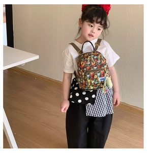 Detail view of cartoon animal print backpack for kids featuring side plush toy charm