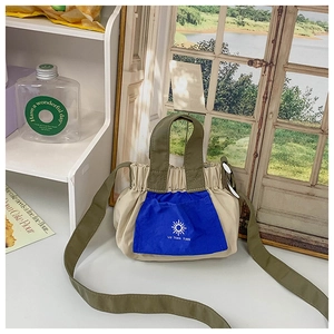 Detail of a casual two-tone kids handbag with sun icon and ruched closure design