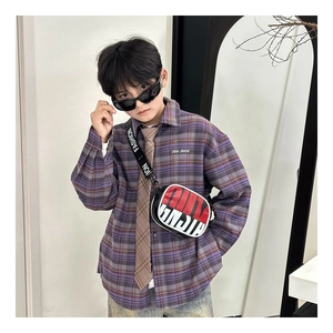 Close-up of kids contrast color crossbody bag with Fashion logo strap on purple shirt