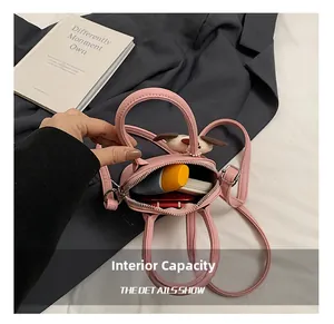 Internal capacity of pink mini leather handbag showing storage for phone and cosmetics