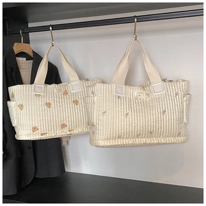 Detailansicht der gesteppten Wickeltasche mit Bärchen-Stickerei und Seitentaschen