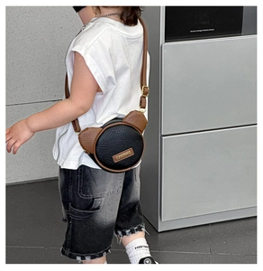 Detail of round mini bear ear crossbody bag with adjustable strap and contrast panel