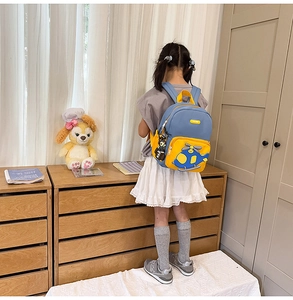 Detail of a kids helicopter backpack featuring blue and yellow contrast and 3D airplane patch