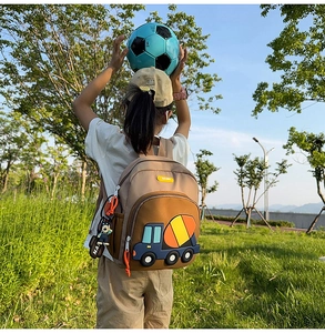 Detailed view of kids backpack with 3D blue construction truck and cute bear charm