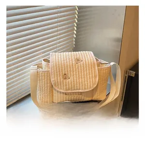 Détail de la broderie ours et de la texture matelassée sur le sac à langer beige