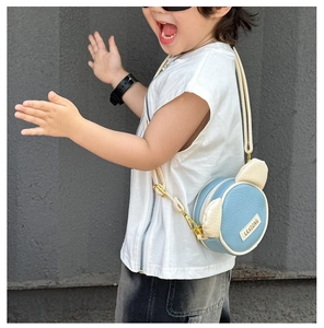 Detail of blue and beige cartoon bear crossbody bag showing adjustable strap and PU texture