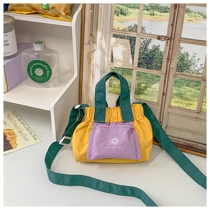 Close-up of color-block canvas bag with yellow, purple and green drawstring design